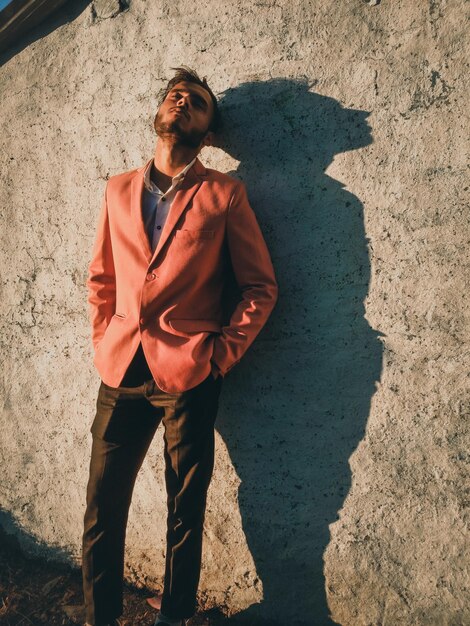 Photo young man wearing suit while standing against wall