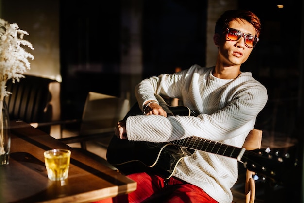 Photo young man wearing sunglasses sitting at home