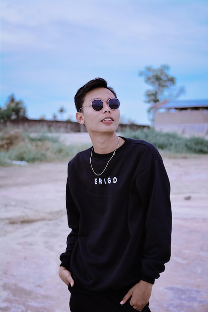 Young man wearing sunglasses standing on land