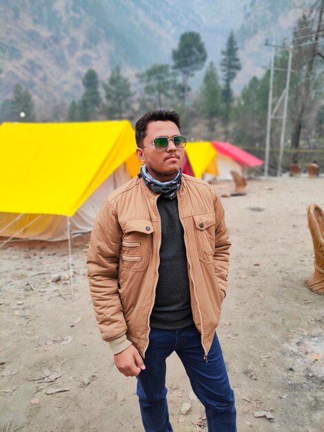 Young man wearing sunglasses standing on land