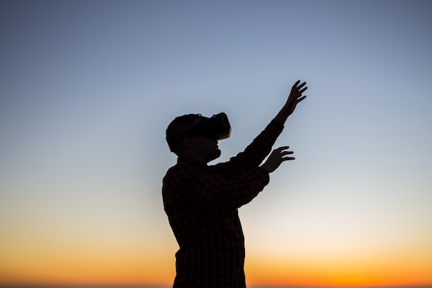 Photo young man wearing virtual reality goggles on sky dreams come true