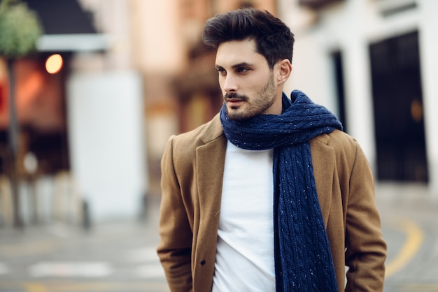 Photo young man wearing winter clothes in the street.