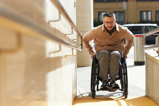 建物のスロープを上がる車椅子の若者