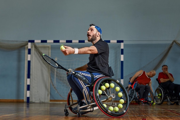 Young man in wheelchair playing tennis on court Wheel Chair Tennis