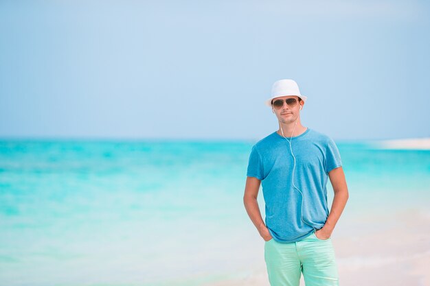 Giovane uomo sulla spiaggia bianca in vacanza