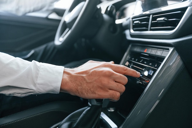 白い服を着た若い男性が自動車ディーラーにいる