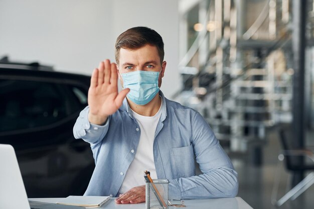 Young man in white shirt and blue jacket works indoors