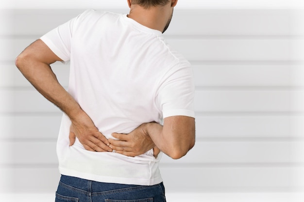 Young man in white shirt with pain in back