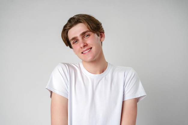 Young man in white tshirt smiles at camera