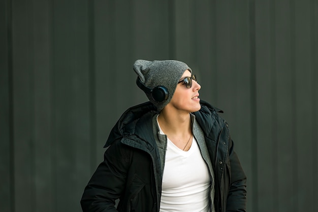 Young Man in the Winter City Streets with Headphones