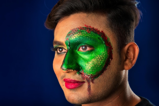 A young man with art creative makeup on his face like a snake Half face portrait with scary zombie makeup or Halloween face art