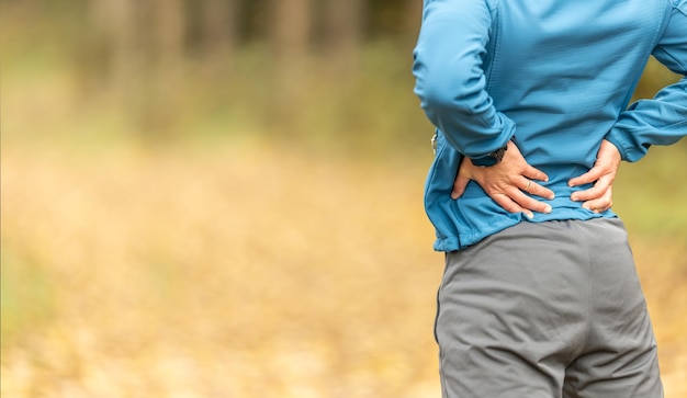 Photo young man with an athletic figure and a lower back injury back pain during sports