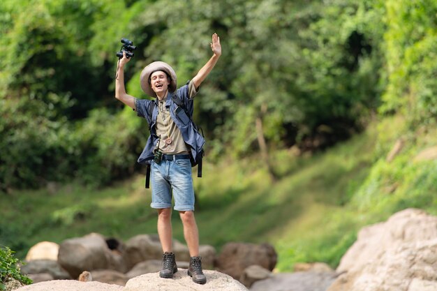 Photo young man with backpack hiking in the forest active lifestyle concept