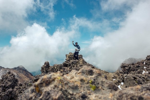 Young man with backpack standing on top of mountain