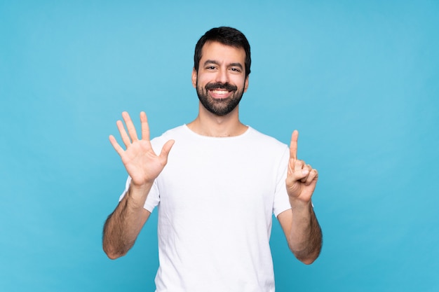 Young man with beard counting six with fingers