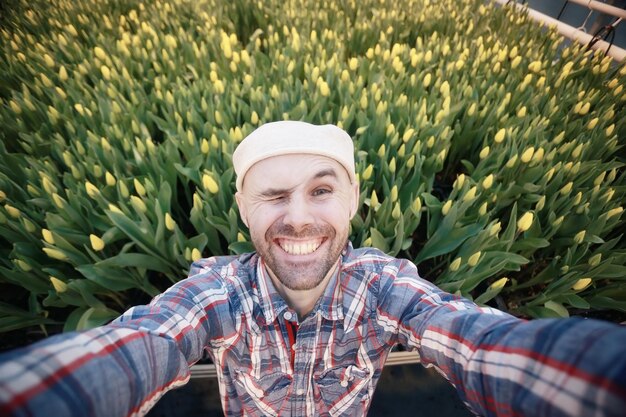 young man with a beard in the field of tulips