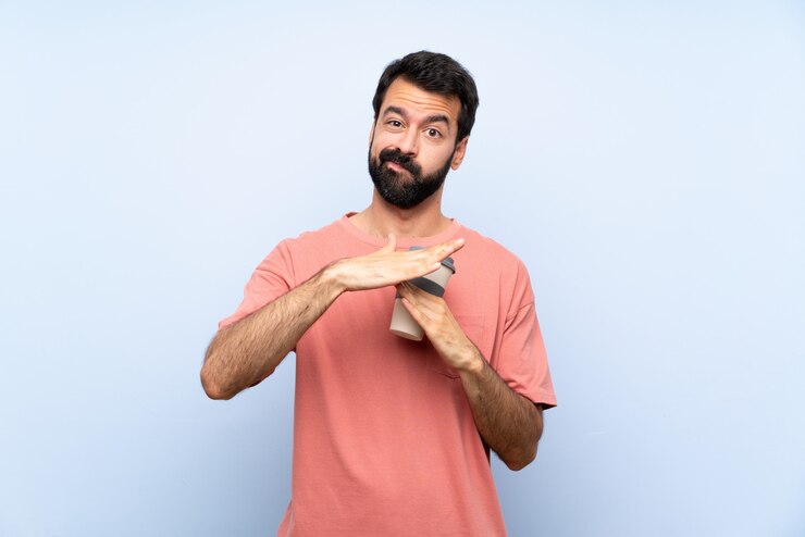 Photo young man with beard holding a take away coffee