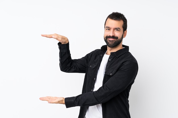 Young man with beard over isolated white holding copyspace to insert an ad