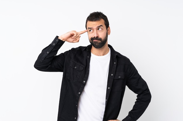 Young man with beard over isolated white  making the gesture of madness putting finger on the head