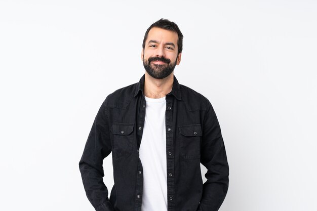 Young man with beard over isolated white wall laughing