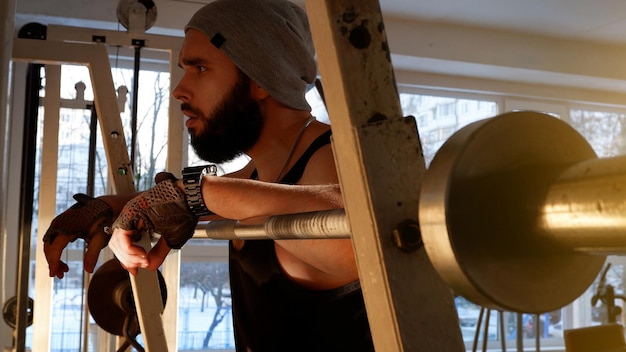 A young man with a beard in an old school gym