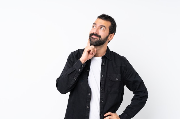 Young man with beard thinking an idea while looking up