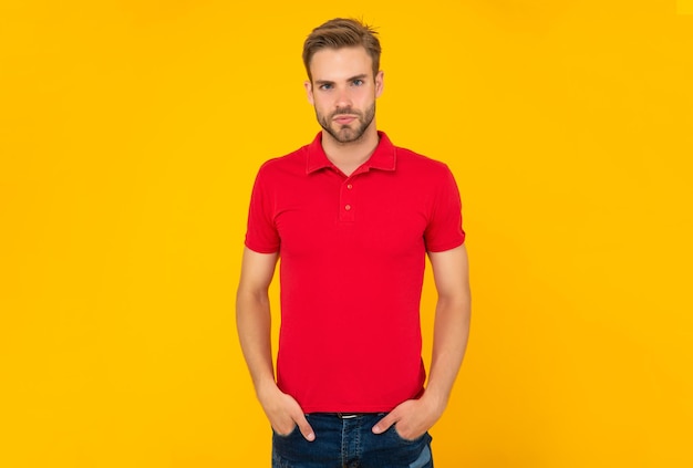 Young man with beard on yellow background. hair and beard care. confident and handsome unshaven guy. male casual fashion. mens beauty. man with bristle in red shirt.