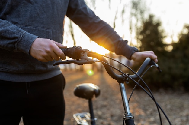 Giovane con la bicicletta all'aperto nel parco