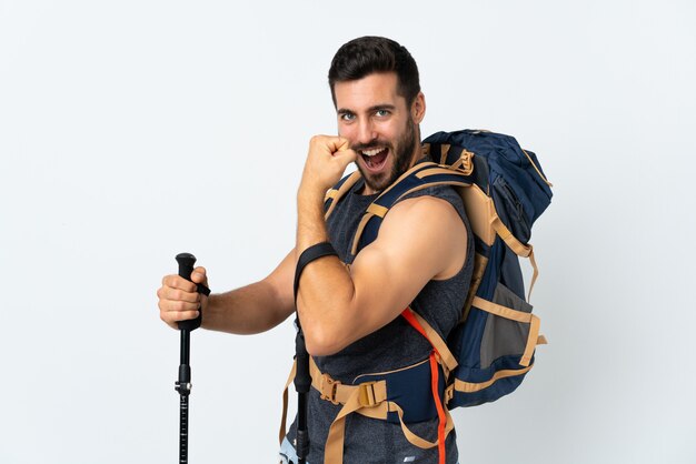 Young man with a big backpack and trekking poles