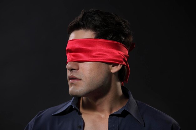 Photo young man with blindfold against black background