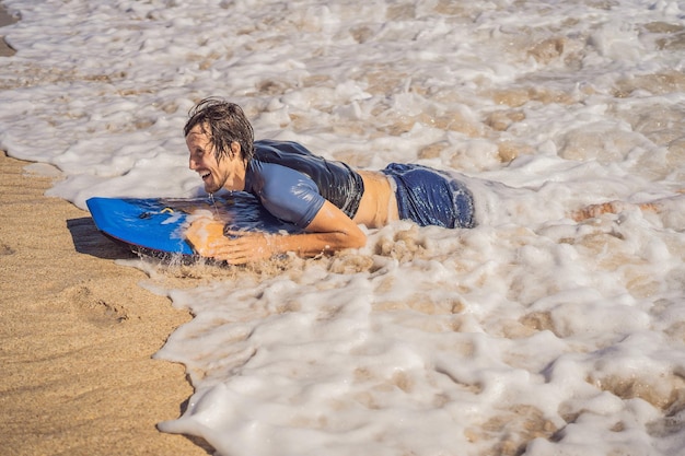 Giovane con boogie board in spiaggia