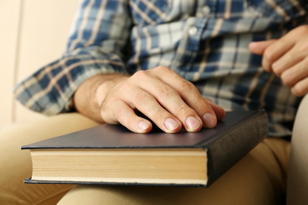 Young man with book on sofa close up