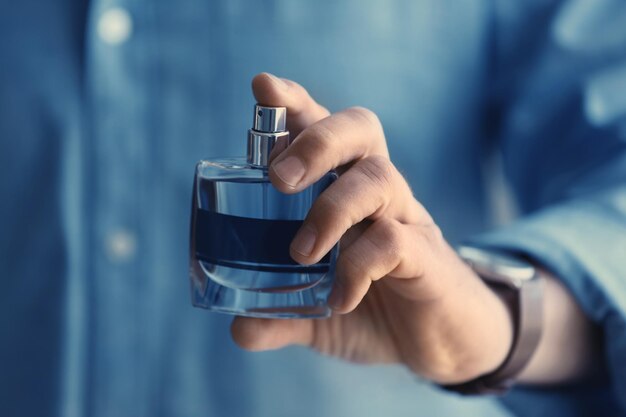 Young man with bottle of perfume closeup