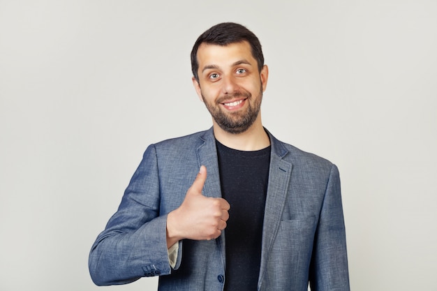 Young man with bristle businessman showing finger up with happy smile