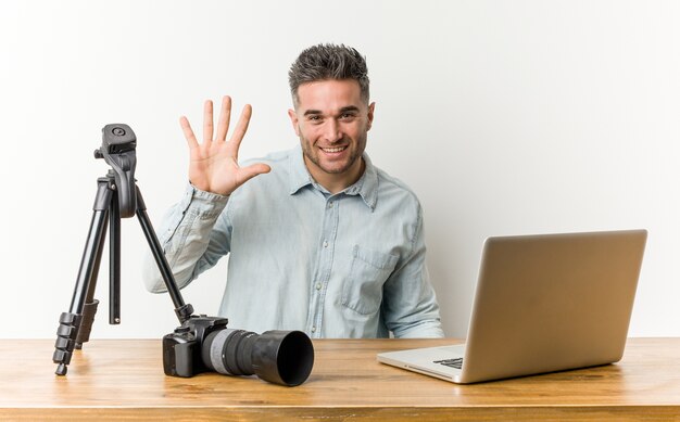 Young man with camera and laptop