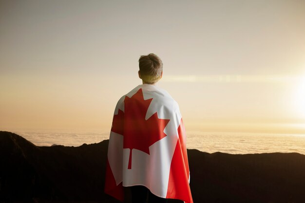 Молодой человек с национальным флагом канады о патриотизме душевных и гордых чувствах