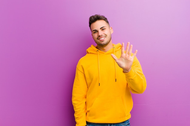 Young man with casual look against purple background