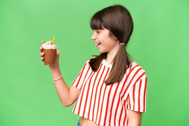 Young man with chocolat milkshake over isolated background with happy expression