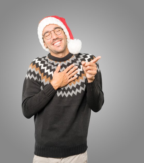 Young man with Christmas hat gesturing