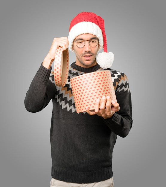 Young man with Christmas hat gesturing