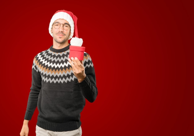 Foto giovane con il cappello di natale che gesturing