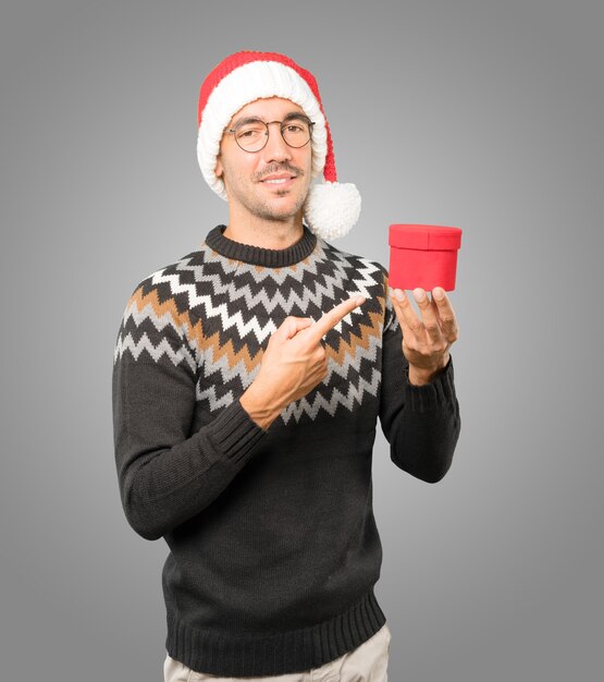 Young man with Christmas hat gesturing