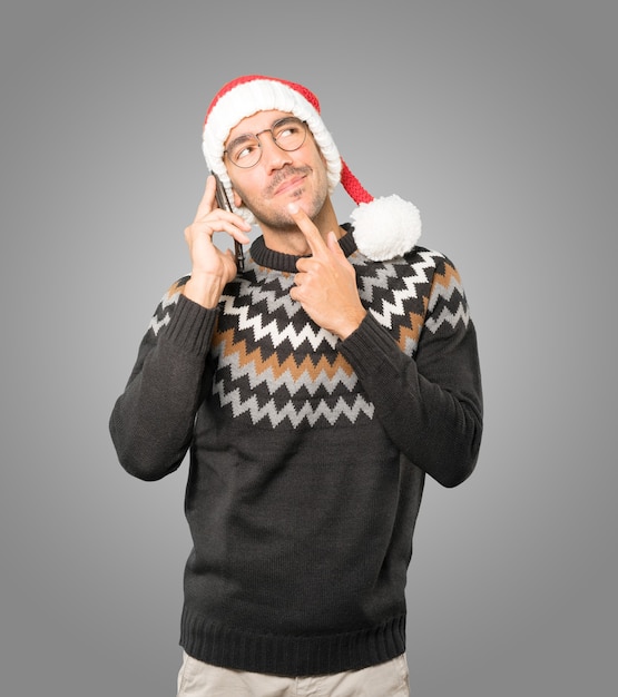 Young man with Christmas hat gesturing