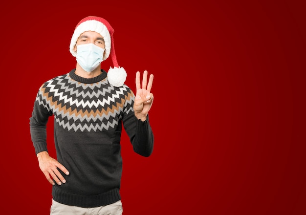 Young man with Christmas hat gesturing