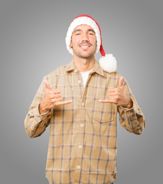 Foto giovane con il cappello di natale che gesturing