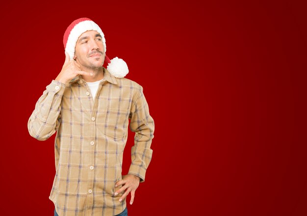 Young man with Christmas hat gesturing