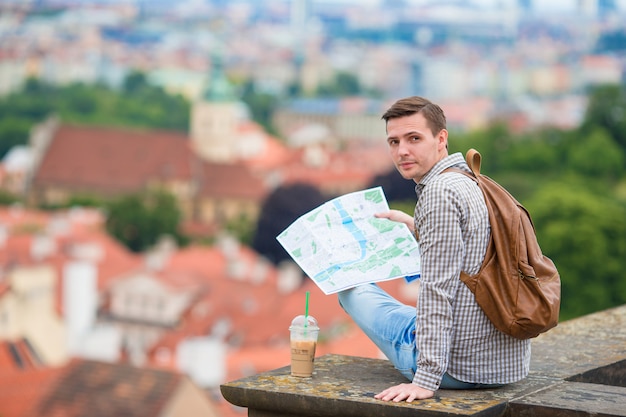 Photo young man with a city map and backpack