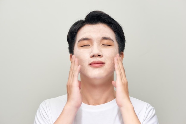 Young man with clay mask on face