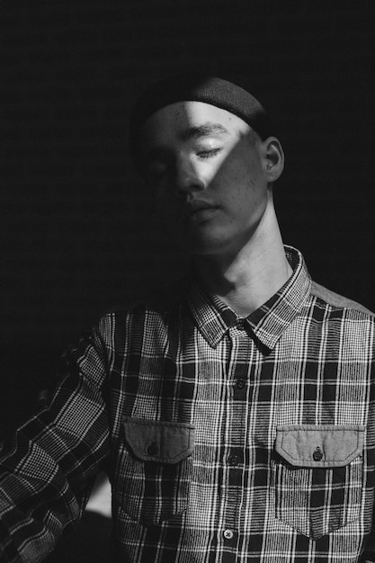 Photo young man with closed eyes in darkroom