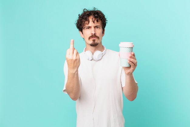 Young man with a coffee feeling angry, annoyed, rebellious and aggressive